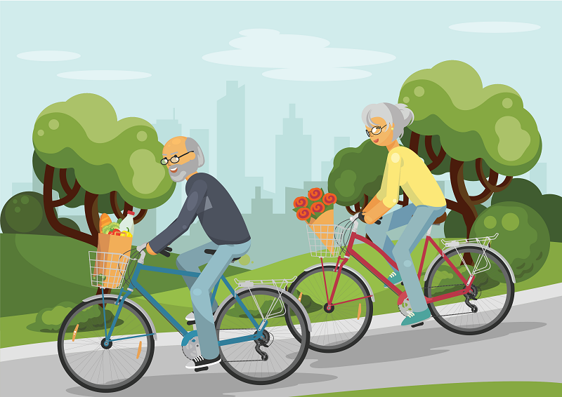 Couple riding bicycles with food and flowers in basket